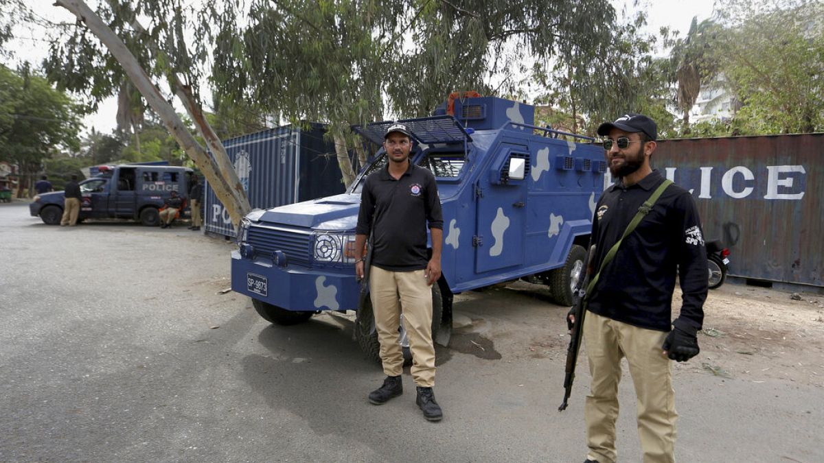 Des policiers gardent une route bloquée par des conteneurs maritimes, à proximité du consulat de France, à Karachi, au Pakistan, jeudi 15 avril 2021.