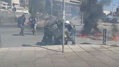Αστυνομικοί επιχειρούν να σβήσουν φωτιά από μολότοφ σε διαδηλωτή