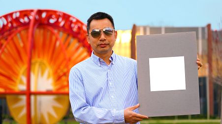 Xiulin Ruan, a Purdue University professor of mechanical engineering, holds up his lab’s sample of the whitest paint on record.