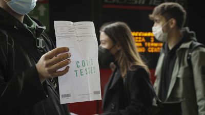 Pasajero mostrando el test negativo antes de subirse al tren