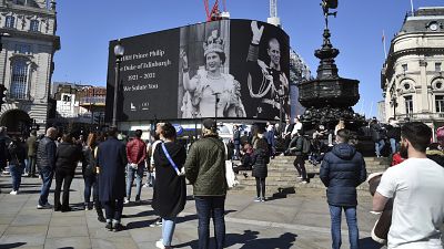 People observe a minute's silence for Britain's Prince Philip at Piccadilly Circus in London.