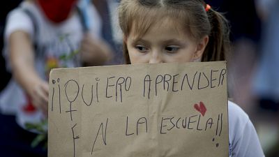 طفلة ترفع لافتة كتب عليها: "أريد التعلم في المدرسة"، وذلك خلال مظاهرة في بيونس ايرس. 2021/04/16