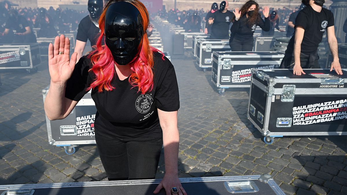 Entertainment workers bang on equipment cases during a flashmob performance called by the 'Bauli in Piazza' movement to protest against restrictions and closures.