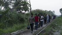 Migrantes caminan por las vías del tren en Palenque, estado de Chiapas, México, el miércoles 10 de febrero de 2021