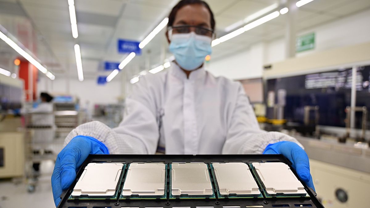 Az Intel maláj gyárának munkatársa mutatja a cég új fejlesztésű processzorait