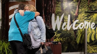 Families are reunited as travellers arrive on the first flight from Sydney, in Wellington.