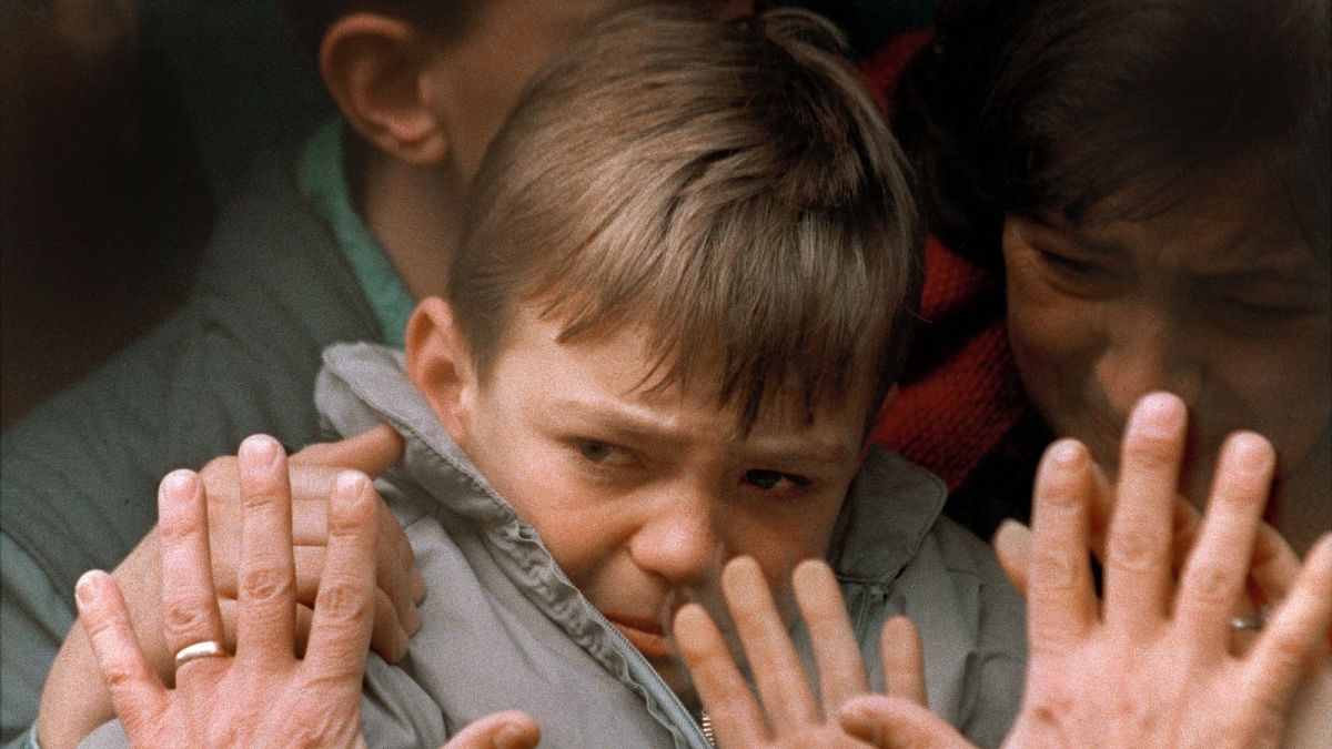 Egy menekültként buszra ültetett kisfiút búcsúztatnak szülei a viszontlátás reményében, Szarajevóban, 1992-ben