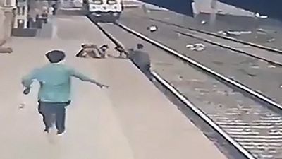 رجل ينقذ طفلًا فقد توازنه وسقط في مسار قطار قادم في محطة سكة حديد فانغاني في مومباي- الهند.