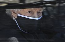 Britain's Queen Elizabeth II follows the coffin in a car during the funeral of Prince Philip inside Windsor Castle in Windsor, England Saturday April 17, 2021.