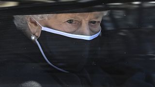 Britain's Queen Elizabeth II follows the coffin in a car during the funeral of Prince Philip inside Windsor Castle in Windsor, England Saturday April 17, 2021.