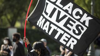 A demonstrator holds a Black Lives Matter flag outside Los Angeles Mayor Garcetti's house after a guilty verdict was announced at the trial of former Minneapolis police Office