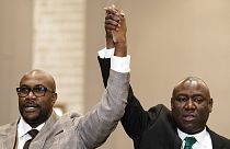 Philonise Floyd, brother of George Floyd, left, and attorney Ben Crump raise their hands in triumph during a news conference after the murder conviction against former Minneap