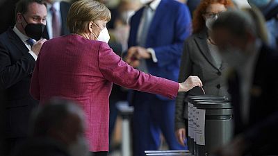 Angela Merkel dépose un bulletin dans une urne, lors d'une session parlementaire, Berlin, le 21 avril 2021