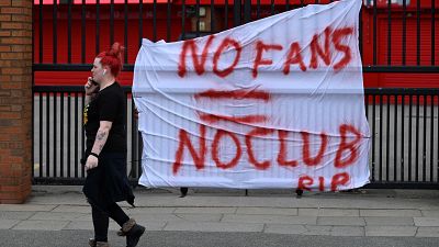 Banners critical of the European Super League project hang from the railings of Anfield stadium, Liverpool.