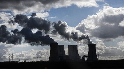 Water steam rises from the cooling towers of the coal-fired power station of German 