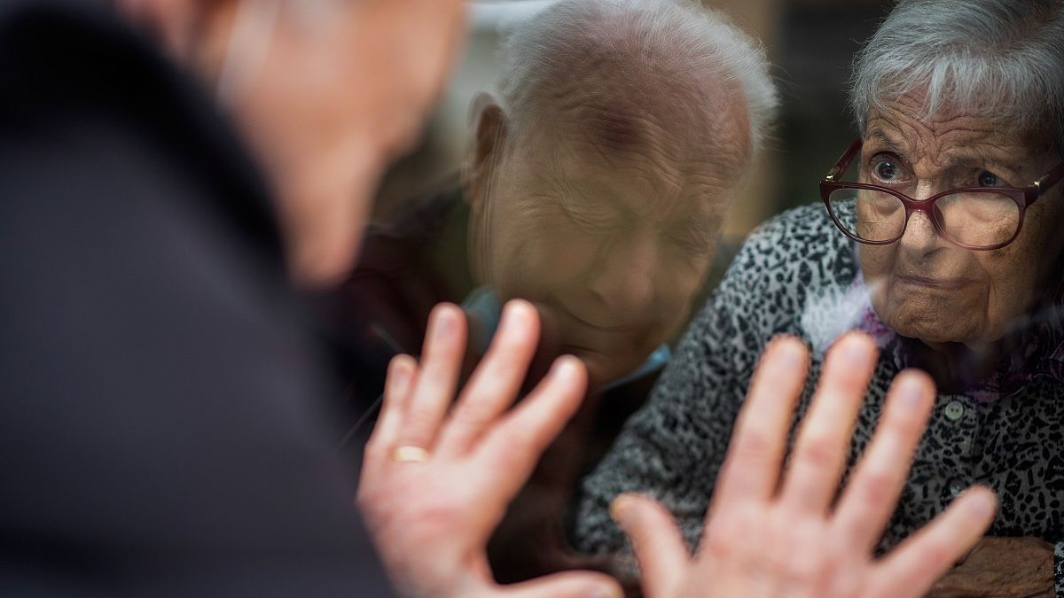 Javier Anto, 90, speaks to his wife Carmen Panzano, 92, through the window separating the nursing home from the street in Barcelona, Spain. April 21, 2021.