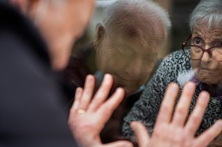 Javier Anto, 90, speaks to his wife Carmen Panzano, 92, through the window separating the nursing home from the street in Barcelona, Spain. April 21, 2021.