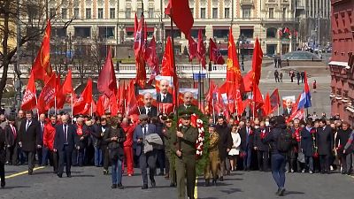 Communists marching with flags and portraits of late Soviet leader, Vladimir Lenin.