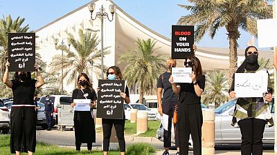  كويتيات يرفعن لافتات خلال تجمع للتنديد بالعنف ضد المرأة، خارج مجلس الأمة، في العاصمة الكويت، في 22 أبريل 2021، بعد مقتل فرح حمزة