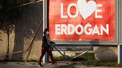 A woman wearing a face mask walks by a poster that reads "Love Erdogan" in the Turkish occupied area at the Turkish Cypriot breakaway north part of divided capital Nicosia A woman wearing a face mask walks by a poster that reads "Love Erdogan" in the Turkish occupied area at the Turkish Cypriot breakaway north part of divided capital Nicosia