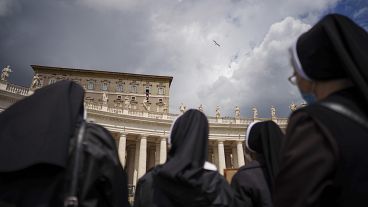 Nuns watch Pope Francis as he recites the Regina Caeli noon prayer from the window of his studio overlooking St.Peter's Square, at the Vatican, Sunday, April 18, 2021.