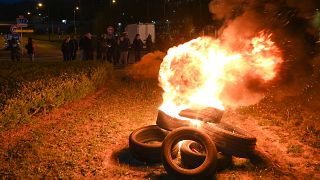 French fishermen stand near burning tyres as they gather as part of a protest action against the delay in granting licenses to access British waters