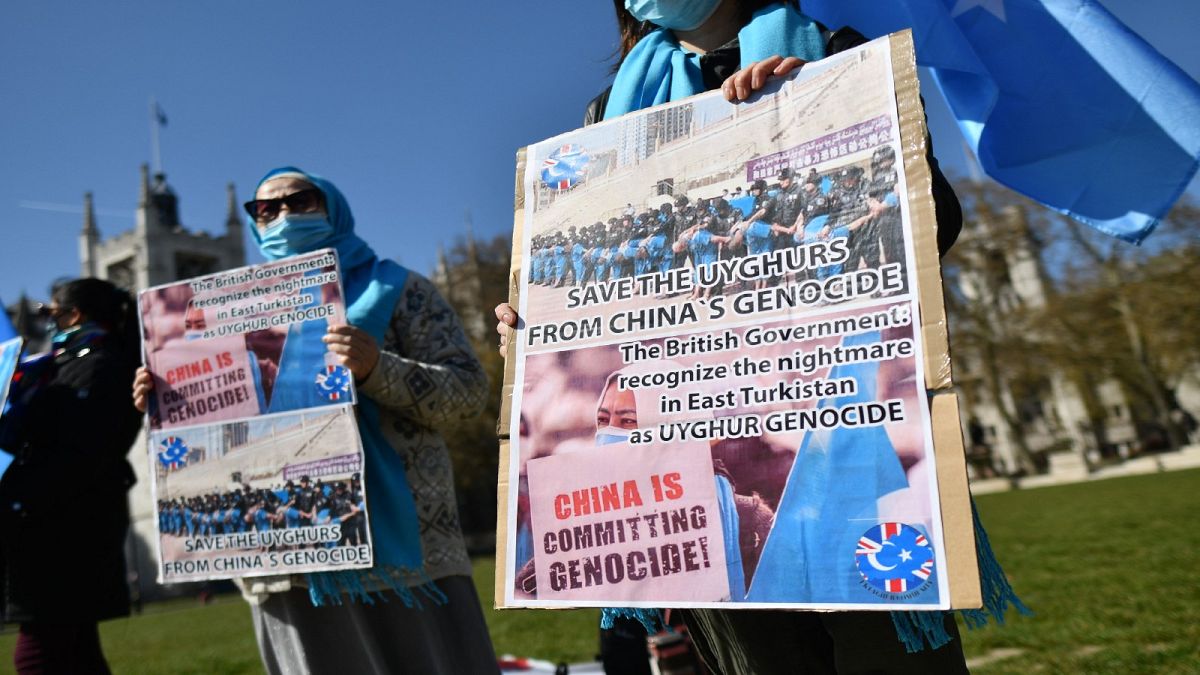 أفراد من مجتمع الأويغور يحملون لافتات أثناء تظاهرهم لدعوة البرلمان البريطاني للتصويت للاعتراف بالاضطهاد المزعوم لأقلية الأويغور المسلمة في الصين باعتباره إبادة جماعية
