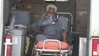 A COVID-19 patient waits inside an ambulance to be attended to and admitted into a dedicated COVID-19 government hospital in Ahmedabad, India.