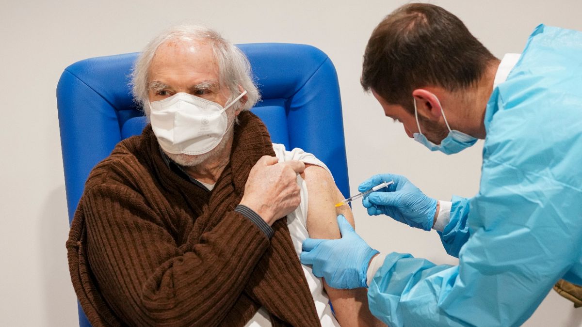 A health worker administers a dose of the Moderna COVID-19 vaccine to a man in his 80s at a vaccine center in Rome's Auditorium, Monday, Feb. 15, 2021.