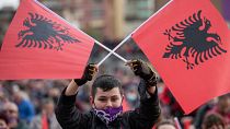 مؤيد للحزب الاشتراكي يلوح بالعلم الألباني يشارك في المسيرة السياسية في مدينة دوريس، ألبانيا يوم الجمعة 23 أبريل 2021.