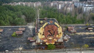 The rusty emblem of the Soviet Union is seen over the ghost town of Pripyat close to the Chernobyl nuclear plant, Ukraine, Thursday, April 15, 2021. 