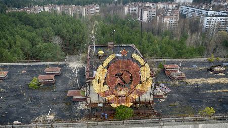 The rusty emblem of the Soviet Union is seen over the ghost town of Pripyat close to the Chernobyl nuclear plant, Ukraine, Thursday, April 15, 2021.