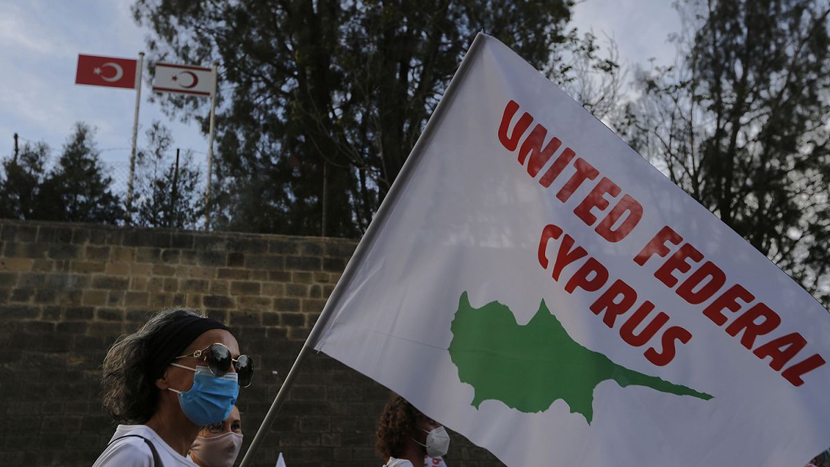 Kıbrıs'ın birleşmesi için düzenlenen gösteride elinde 'Birleşik Federal Kıbrıs' yazılı pankart taşıyan barış yanlısı bir aktivist