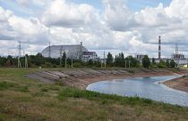 The view over the cooling pond of the Chernobyl nuclear power plant and reactor No. 4, covered with the protective shield.
