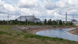 The view over the cooling pond of the Chernobyl nuclear power plant and reactor No. 4, covered with the protective shield. 