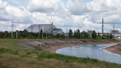 Вид на пруд-охладитель Чернобыльской АЭС и реактор №4, закрытый защитным экраном.