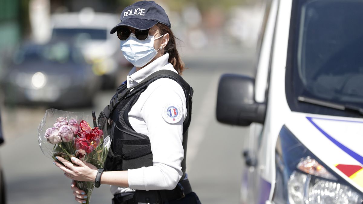 Une policière tient des fleurs que des habitants de Rambouillet lui ont donné, pour qu'il soit déposé sur les lieux de l'assassinat de Stéphanie Monfermé