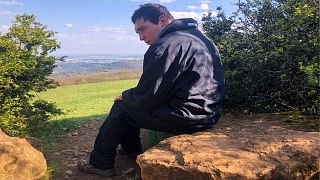 Eli sits on his favourite rock after a walk near his home