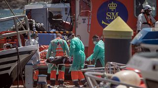 FILE: A migrant woman is disembarked on a stretcher from a Spanish coast guard vessel upon its arrival at the port of Los Cristianos, Tenerife, March 26, 2021