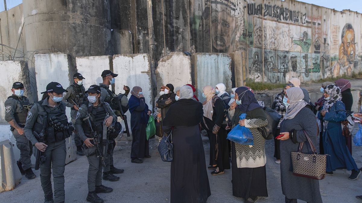 Palestinian women wait to cross the Qalandia checkpoint between the West Bank city of Ramallah and Jerusalem, during the the Muslim holy month of Ramadan, April 16, 2021.