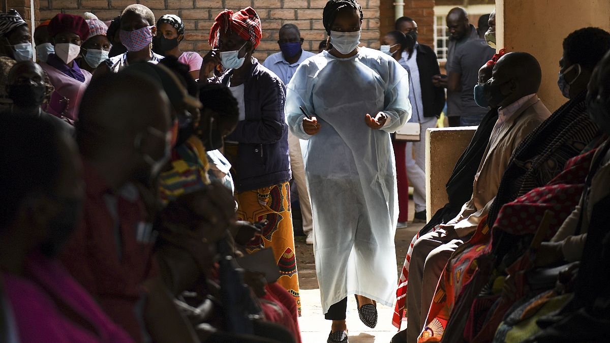 Numbers are handed out to people waiting to receive the AstraZeneca COVID-19 vaccine at Ndirande Health Centre in Blantyre Malawi on March 29, 2021.