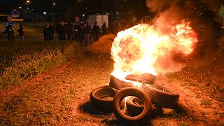 French fishermen stand near burning tyres as they gather as part of a protest action against the delay in granting licenses to access British waters