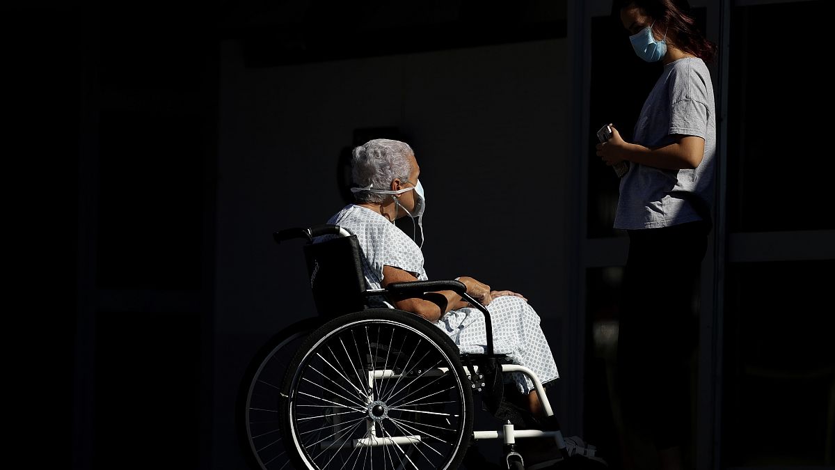Betegszállítóra vár a 74 éves Elizabeth Nader és unokája a brasiliai HRAN kórház előtt