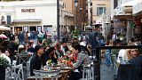 People sit at a cafe restaurant in Rome, Monday, April 26, 2021.