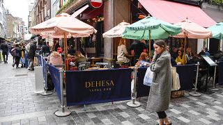 People sit at setup tables outside a pub in Soho, in London, Thursday, April 15, 2021.