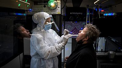 A person is tested inside a mobile coronavirus testing facility, in Ishoej, Denmark.