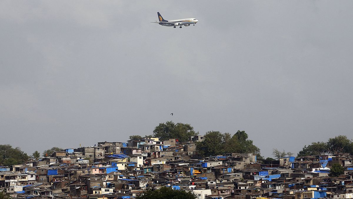 طائرة تحلق فوق الأكواخ المجاورة لمطار تشاتراباتي شيفاجي بينما تستعد للهبوط في مومباي، الهند.