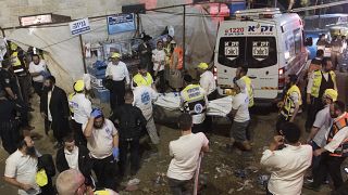 Israeli security officials and rescuers carry a body of a victim who died during a Lag Ba'Omer celebrations at Mt. Meron in northern Israel, Friday, April 30, 2021. 