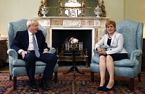 In this Monday. July 29, 2019 file photo, Scotland's First Minister Nicola Sturgeon, right, sits with Britain's Prime Minister Boris Johnson, in Bute House, ahead of their mee