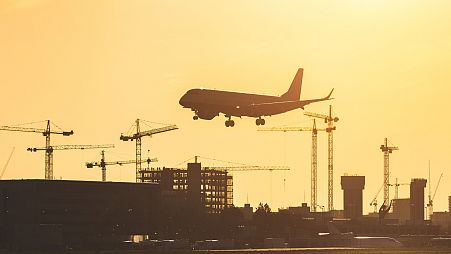 A jet lands at London City Airport at sunset.